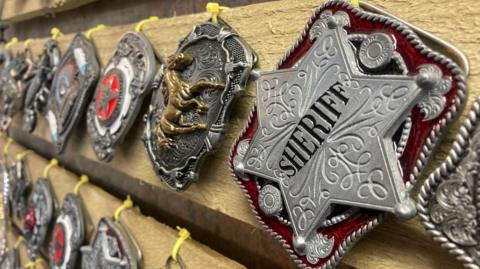 A sheriff badge-style boot buckle in silver coloured metal