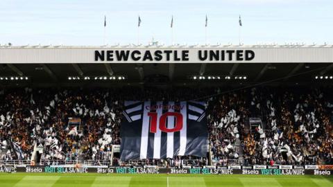 General view inside the stadium as fans hold a flag featuring the shirt of Anthony Gordon of Newcastle United prior to the Premier League match between Newcastle United FC and Manchester City FC at St James' Park