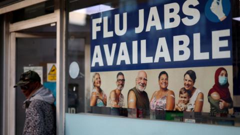 Sign in pharmacy window advertising flu jabs