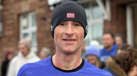 Albert Johnson wearing a blue T-shirt an black hat