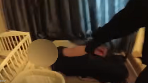 Police body-worn cameras showing the moment a man was found lying in a child's-size bed in an empty house. An officer's arm can be seen grabbing the man's up and pulling him up as he is woken up.