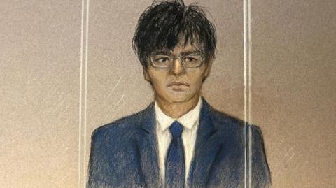 Court drawing of Zhenhao Zou, a man in a suit wearing glasses, sitting in the dock of a court