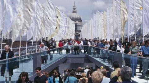 People crossing the bridge on the day it opened in 2000.