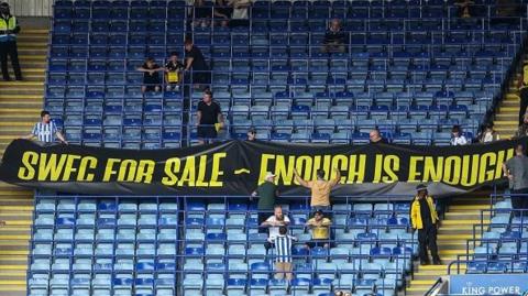 Sheffield Wednesday fans holding up banner in protest to Dejphon Chansiri.