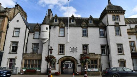 The Chambers Institution in Peebles a large building with turrets and lots of windows and a gated entrance
