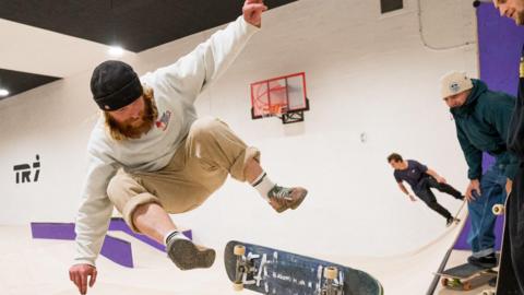 Man jumping off his skateboard as a trick