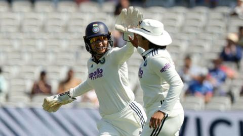 India's Shafali Verma celebrates with Yastika Bhatia after taking the catch to dismiss England's Amy Jones, off the bowling of Sneh Rana