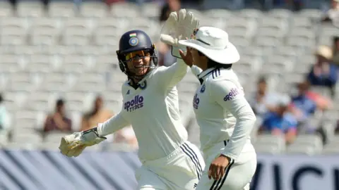India's Shafali Verma celebrates with Yastika Bhatia after taking the catch to dismiss England's Amy Jones, off the bowling of Sneh Rana