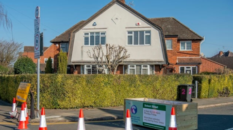 A house, a road and some traffic cones