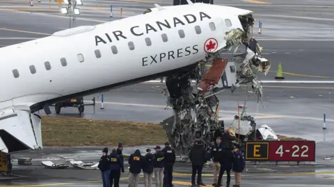 Debris hangs from a damaged Air Canada Express jet that had collided with a ground vehicle 