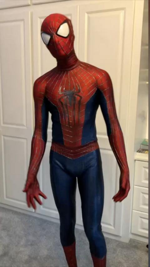Person indoors in a full body red and blue spiderman suit