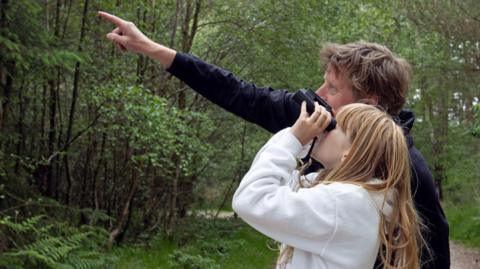 Girl and father watching birds