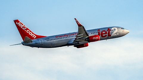 A picture of a Jet 2 plane. It is silver and red in colour. 