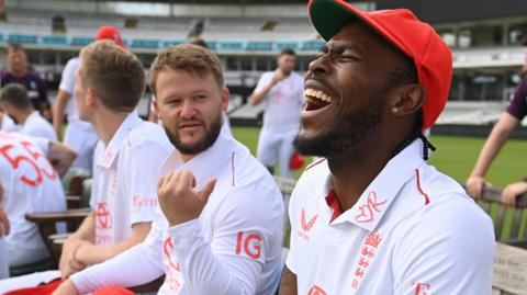 Jofra Archer, right, laughs while sat beside Ben Duckett, who is gesturing behind him