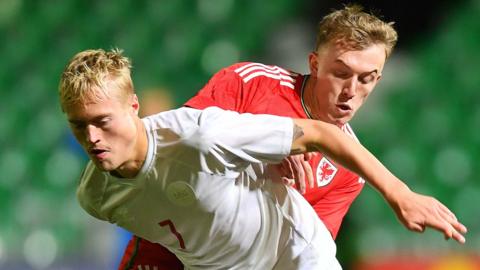 Tobias Bech of Denmark is tackled by Eli King of Wales