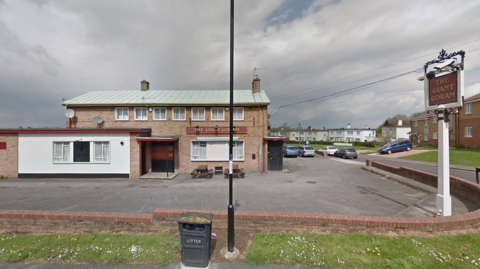 A building with a red sign which reads 'The giant goram'