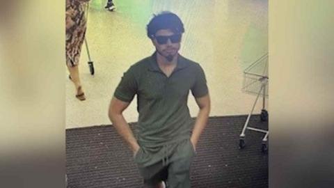 CCTV image of a man wearing green shirt and sunglasses 