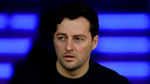 Ryan Mason sits in the dugout during a match