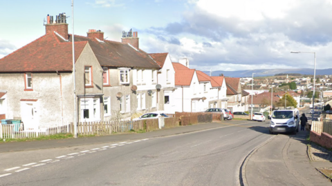 a screenshot from google maps of a street in a built up area.