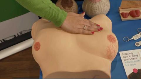 Someone pressing down on a dummy chest plate.