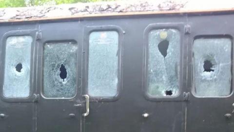 Close up of five smashed windows on a railway carriage on the Lavender Line.