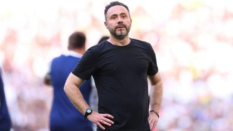 Roberto de Zerbi with his hands on his hips on the touchline