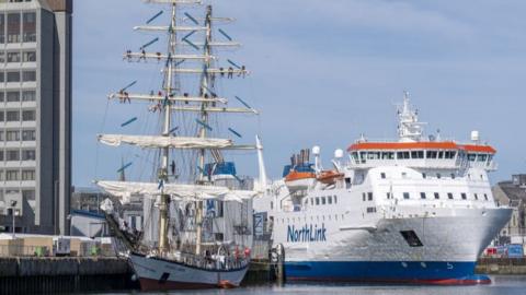 Tall ship in Aberdeen, with a white NorthLink ferry alongside, in Aberdeen harbour.