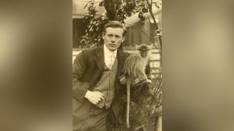 A man standing next to a monkey