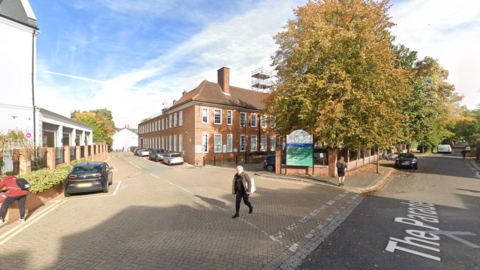 A brick building with white windows. 