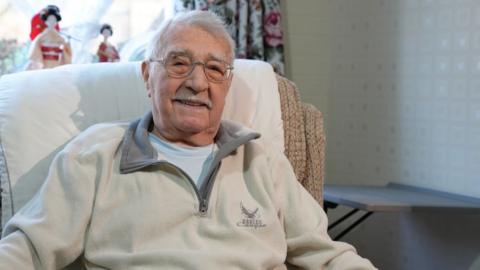 Jack Hearn sits in an armchair in his living room.