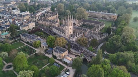 Crowds gather around Magdalen Tower on Oxford High Street.