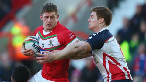 Larne Patrick of Wales is tackled by the USA defence