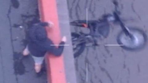 A man is seen throwing a bike off a bridge