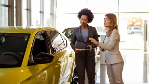 Black Female Vehicle Dealer Showing Woman New Car
