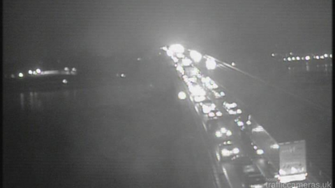 A CCTV camera of cars and lorries queuing behind one another on a busy road 