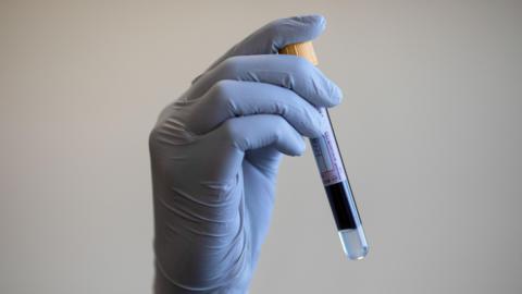 File photo dated 05/06/2020 of a paramedic holding a test tube containing a blood sample.