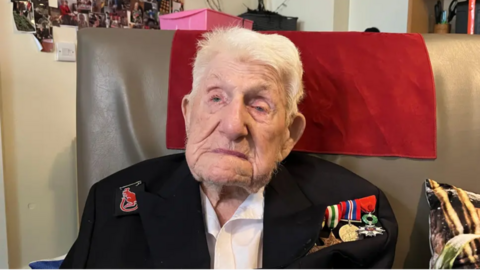 An image of an elderley man with his war medals