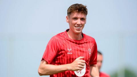 Oisin Gallagher of Lincoln City jogging and smiling during the pre-match warm-up prior to the pre-season friendly match against Leyton Orient in Murcia, Spain.
