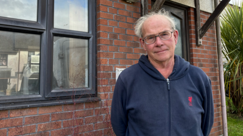 Veryan parish councillor Luke Dunstone outside the empty house. 