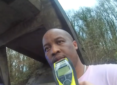 Vincent Lime on the side of the M4. He is attempting to do a road side breath test. The image is from a body worn camera.
