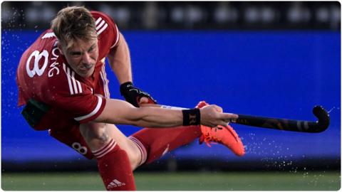 Gareth Furlong powerfully hitting the ball with his hockey stick