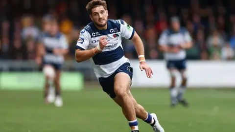 Samuel Maunder of Coventry chases the ball during the Champ Rugby match .