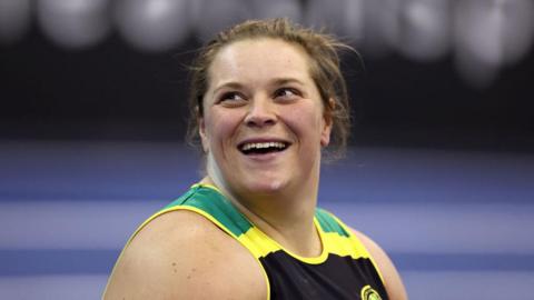 Sophie McKinna looking upwards to the left. She is smiling. The picture has been taken during a shot put competition.