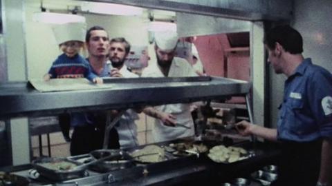 Wilf and kitchen staff stand behind a food counter