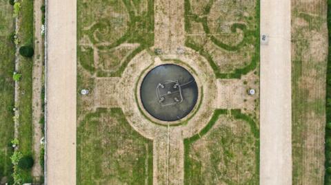 Scorched grass at Chatsworth reveals an outline of an ornate 17th-century garden.