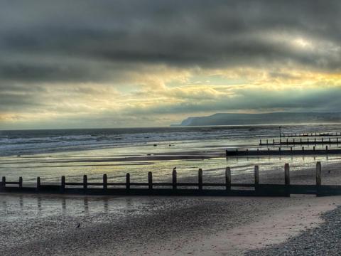Grey sky over the coast with headland in the distance 