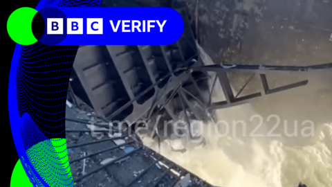 A breach in a dam with a large amount of water pouring out of it