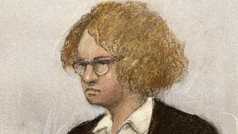 A sketch shows Gwyn Samuels standing in the dock, wearing a dark coloured jacket and a white shirt, with curly ginger hair and glasses. Next to her is a female security guard with tied-back hair and glasses.
