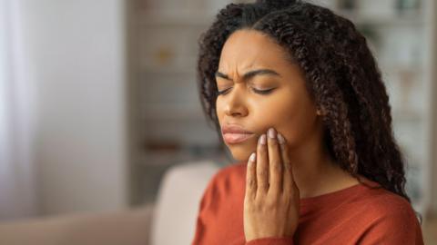Young Black Woman Suffering From Toothache at Home - stock photo