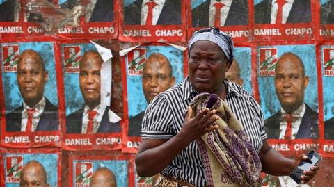 A woman reacts to tear gas in Maputo on 21 October.